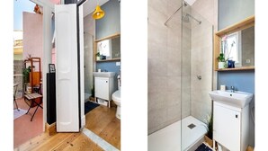 Een badkamer met douche, wastafel en spiegel.