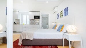 A modern bedroom with a large bed, bedside tables, and a red rug. - Lisbon Prime Aparts - Baixa (Lisboa)