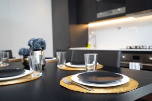 Una cocina moderna con encimeras negras, armarios blancos y una isla central.