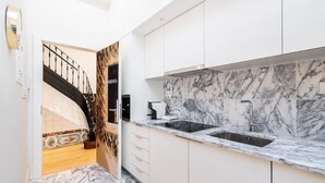 A modern kitchen with marble countertops, a built-in stove, and a sink. - Lisbon Prime Aparts - Baixa (Lisboa)
