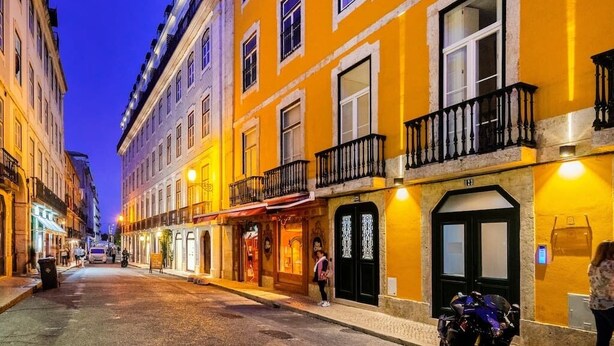 A street with buildings, a motorcycle, and a person walking. - Lisbon Prime Aparts - Baixa (Lisboa)