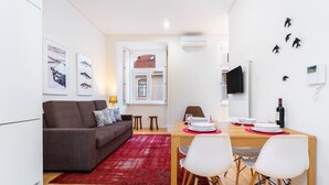 A compact living space with a dining area, a sofa, and a red rug. - Lisbon Prime Aparts - Baixa (Lisboa)