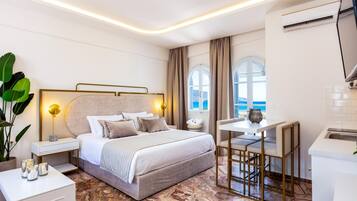 Suite junior, vistas al mar | Caja fuerte, decoración individual, mobiliario individual y escritorio