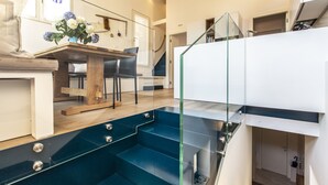 Un interno moderno con una scala, una zona pranzo e una cucina.