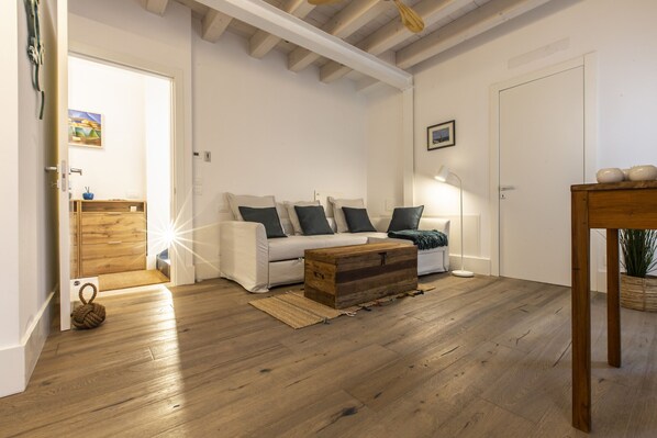 A living room with a sofa, coffee table, and a wooden chest.