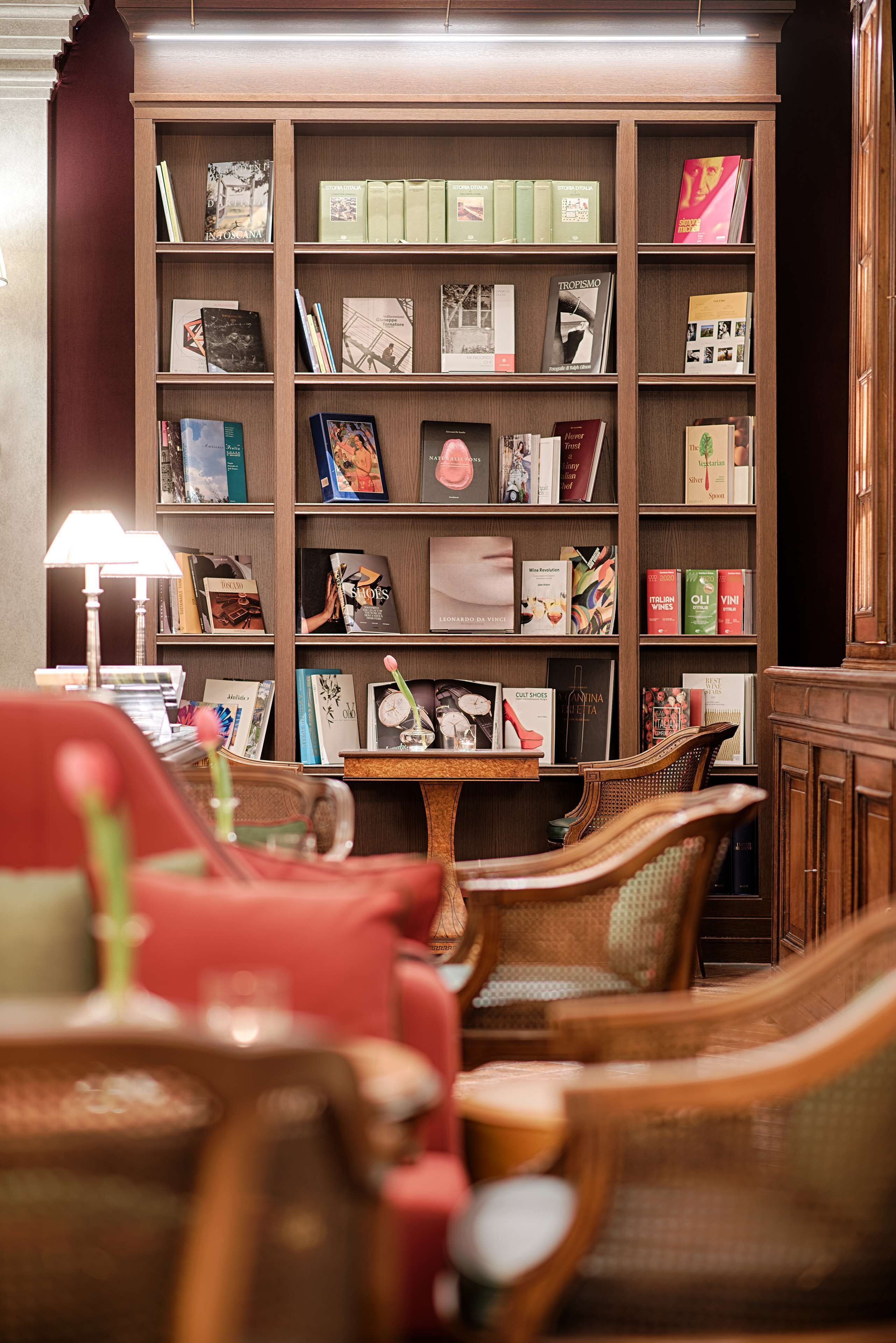 A library with bookshelves, a table, and wicker chairs.