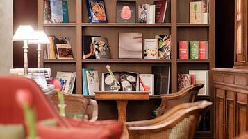 A library with bookshelves, a table, and wicker chairs.