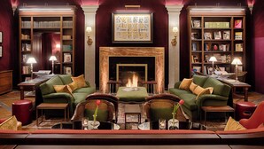 A library with bookshelves, a fireplace, and comfortable seating areas. - Tivoli Palazzo Gaddi Firenze Hotel (Florence)