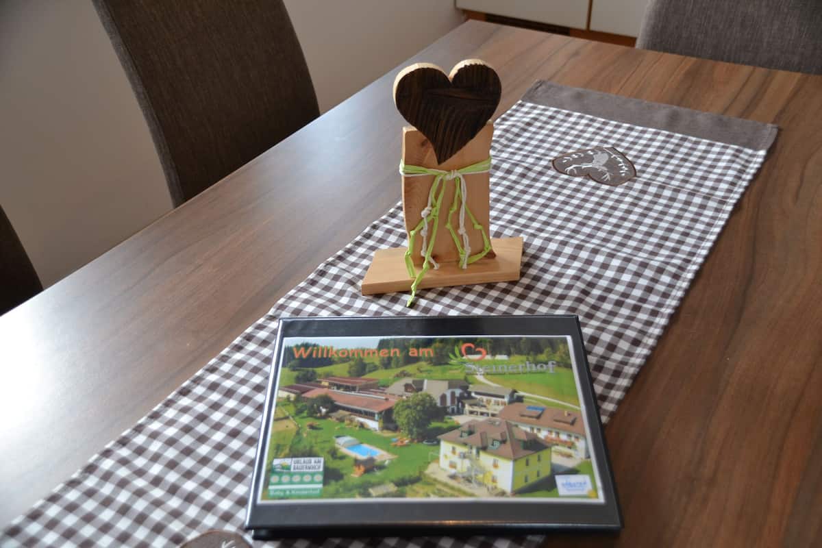 A framed welcome sign with a heart-shaped decoration on a checkered tablecloth.
