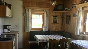 Acogedor interior de cabaña con cocina, comedor y ventana con cortinas.