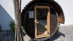 Une structure ronde en bois, dotée d’une porte, d’une enseigne sur la porte et d’une petite fenêtre.