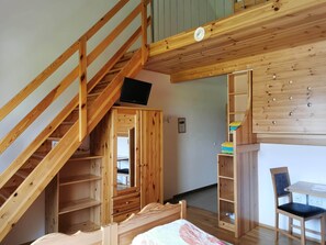A room with a wooden staircase, a bed, a desk, and a chair. - Bio-Bauernhof Hipp-Bruckner (Großschönau)