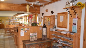 Una librería acogedora con estanterías de madera, un mostrador central y una gran variedad de libros y objetos decorativos.