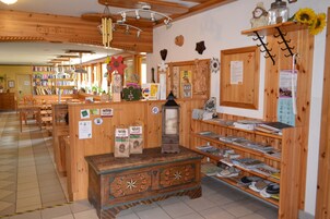 A cozy bookstore with wooden shelves, a central counter, and a variety of books and decorative items.