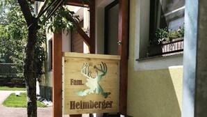 A wooden sign with a deer and the text "Fam. Heimberger" in front of a building. - Ferienwohnung Heimberger (Purgstall an der Erlauf)