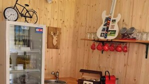 A compact kitchen with a refrigerator, a wooden countertop, a sink, and a guitar mounted on the wall. - Ferienwohnung Heimberger (Purgstall an der Erlauf)