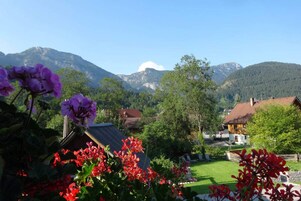 A rural village with traditional houses, a clear sky, and mountains in the background.