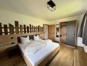 Un lit en bois avec une tête de lit, une table de chevet et une armoire avec un miroir.