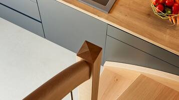 Une cuisine moderne dotée d’un évier en acier inoxydable, d’un plan de travail en bois et d’un escalier en bois.