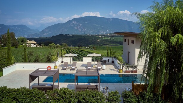 A modern villa with a rooftop pool, lounge chairs, and a view of mountains. - The key to more freedom (Eppan an der Weinstrasse)