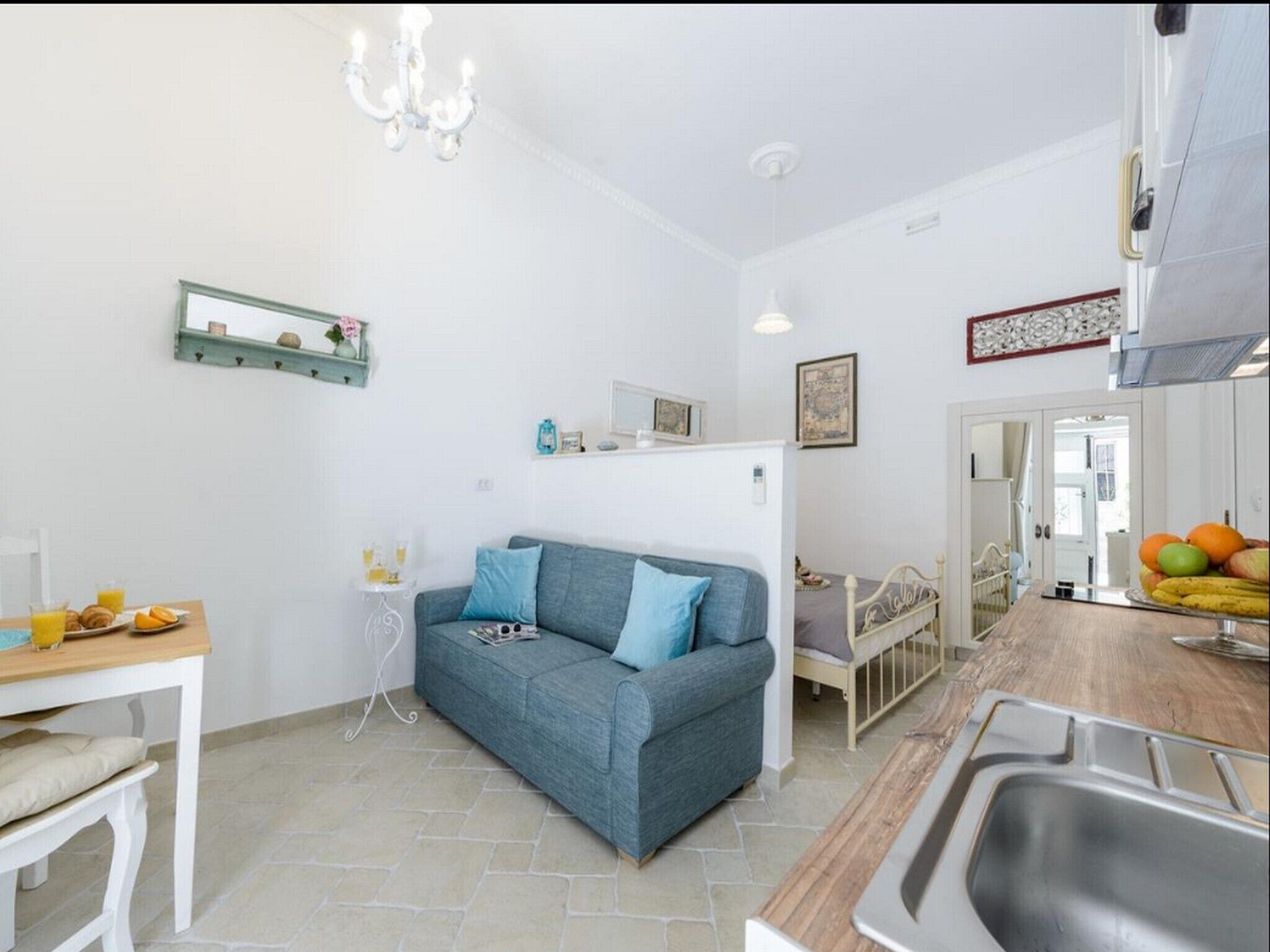 A compact living space with a kitchenette, a dining area, and a sofa.