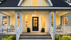 A two-story house with a front porch, a black front door, and a number 230 on the left side. - Tuck'd Away - Newly Built Vacation Home Located in Downtown Saugatuck (Saugatuck)