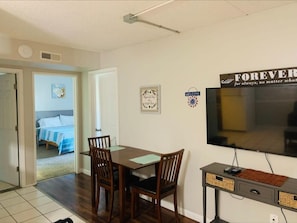 Cozy living space with a dining area, flat-screen TV, and a comfortable bed.