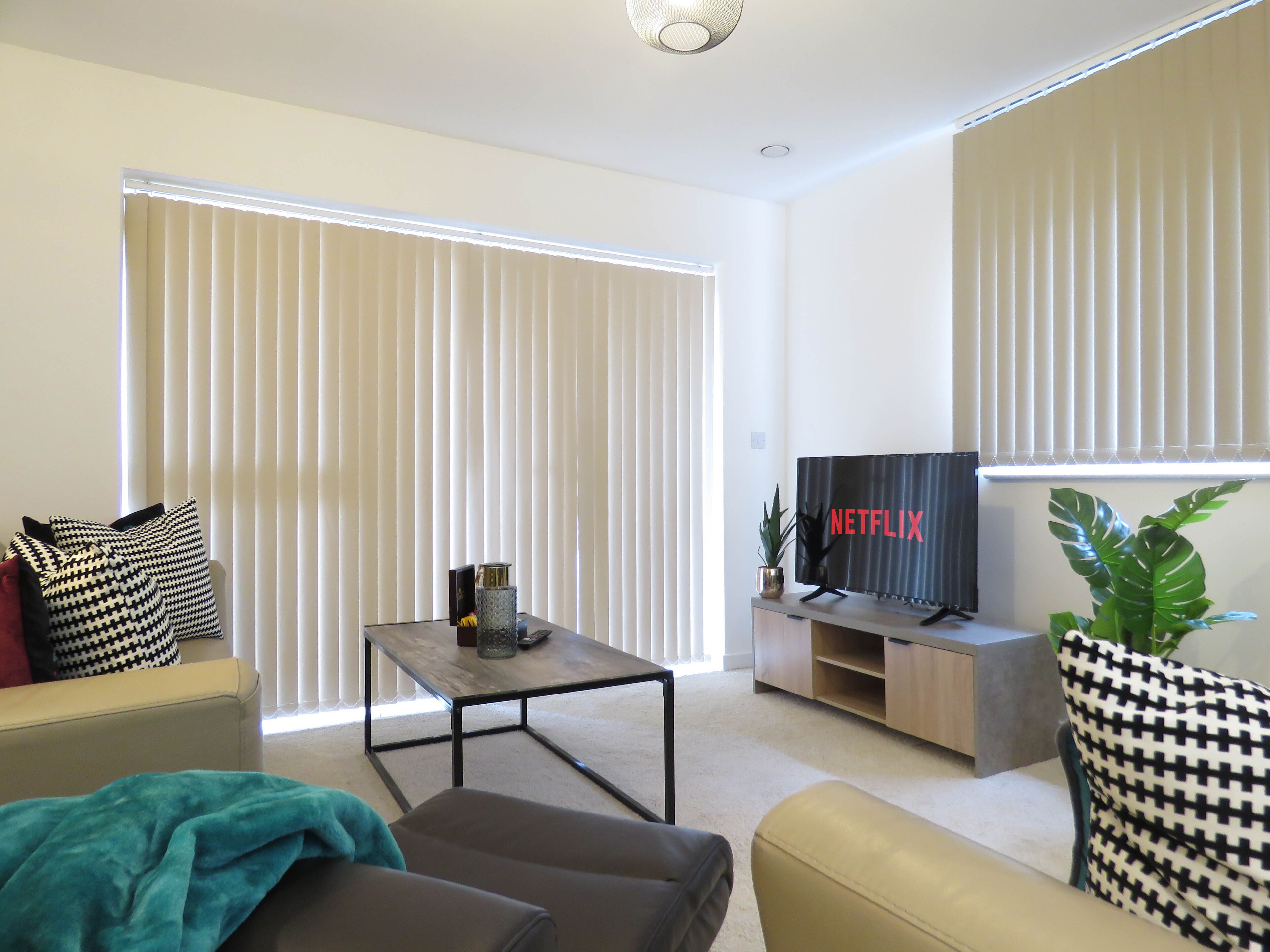 A modern living room with a sofa, a coffee table, and a TV on a stand.
