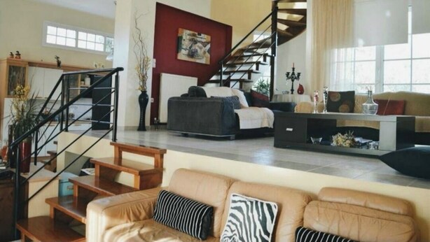A spacious living area with a staircase, a sofa, and a coffee table.