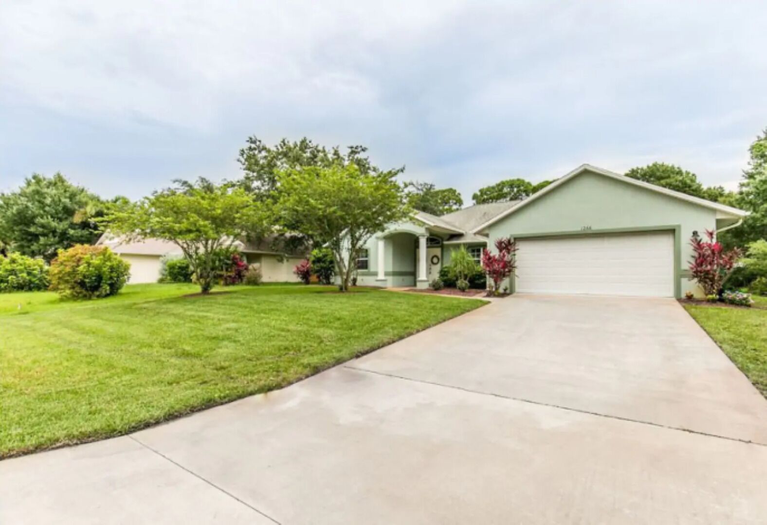 A single-story house with a front driveway, a garage, and a well-maintained lawn.