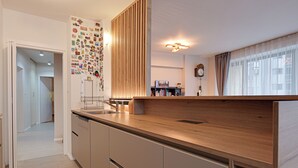 A modern kitchen with a wooden countertop, built-in cabinets, and a wall adorned with various stickers. - Spacious, Comfortable & Purpose-Driven — An Ideal Sofia Stay (Sofia)