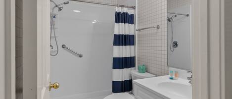 Ein Badezimmer mit Dusche, Toilette und Waschbecken.
