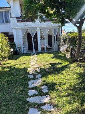 A residential property with a paved pathway leading to a covered porch area.