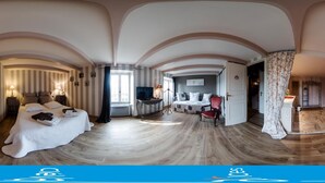 Habitación de hotel con una cama grande, un escritorio, una silla y vistas a la ciudad.