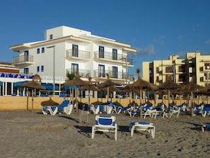 Am Strand, weißer Sandstrand, Strandtücher, Strandbar