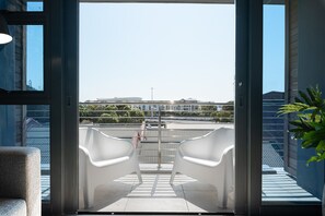 Enjoy the city view from this balcony with two chairs.