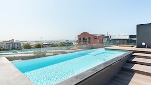 A rooftop swimming pool with a clear view of the cityscape in the background. - Brand New Modern De Waterkant Apartment (Cape Town)