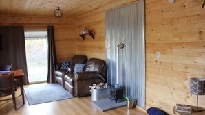 Un interno accogliente con soffitto in legno, un divano in pelle, un tavolo da pranzo e un camino.