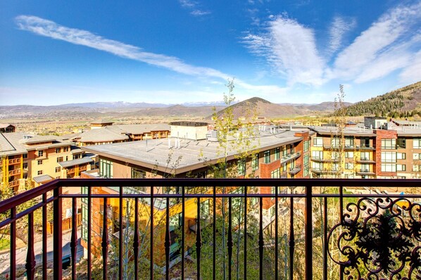 A hotel with multiple buildings, balconies, and a mountainous backdrop.