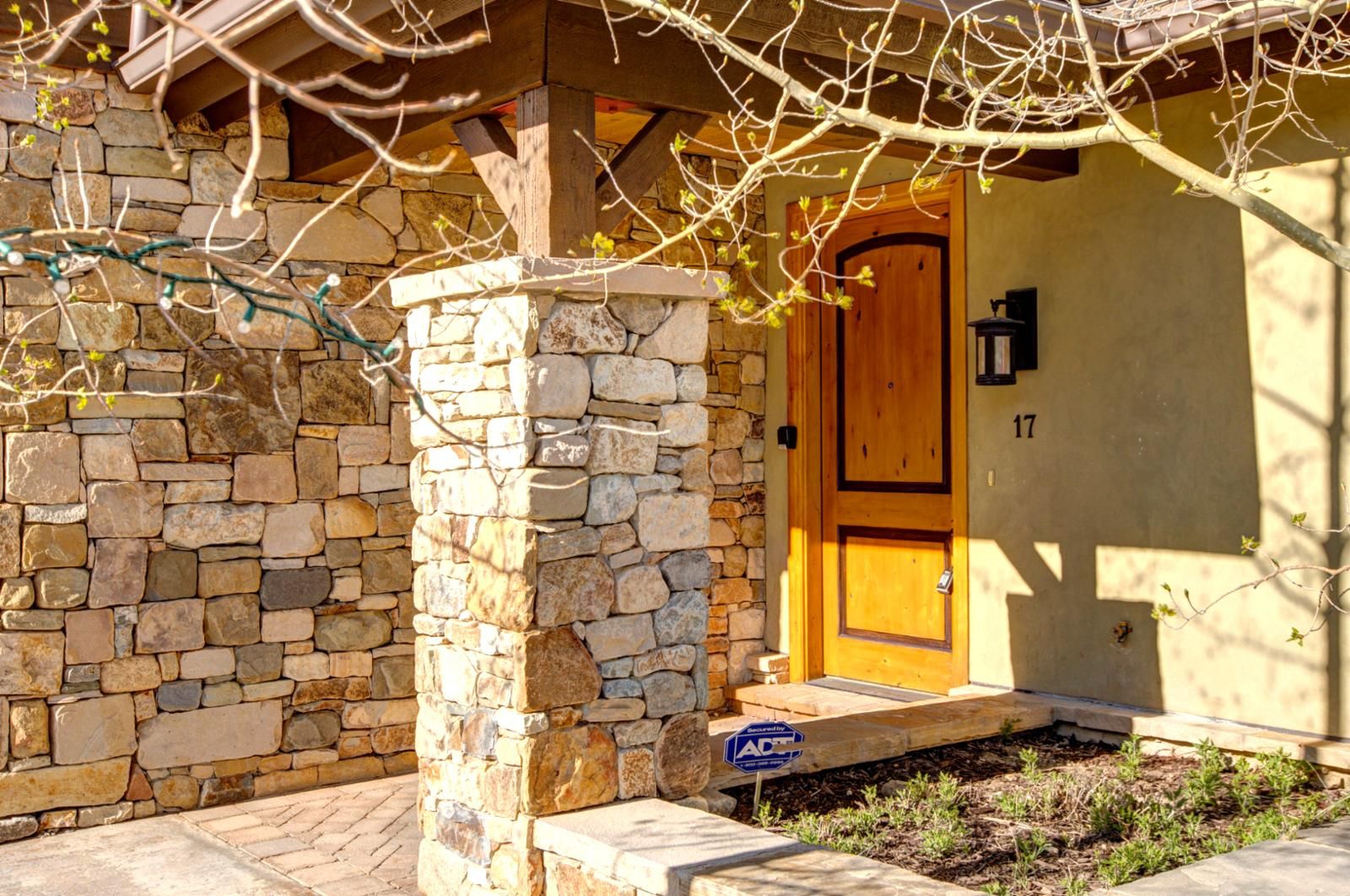 A stone building with a wooden door, a stone pillar, and a sign that reads "ACT".