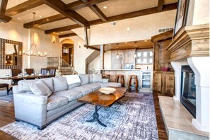 Amplia sala de estar con un sofá modular grande, una mesa de centro de madera y una chimenea.