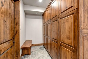 Un pasillo con armarios de madera y un banco.