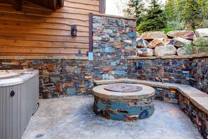 Un muro de piedra con un jacuzzi y una chimenea de piedra.