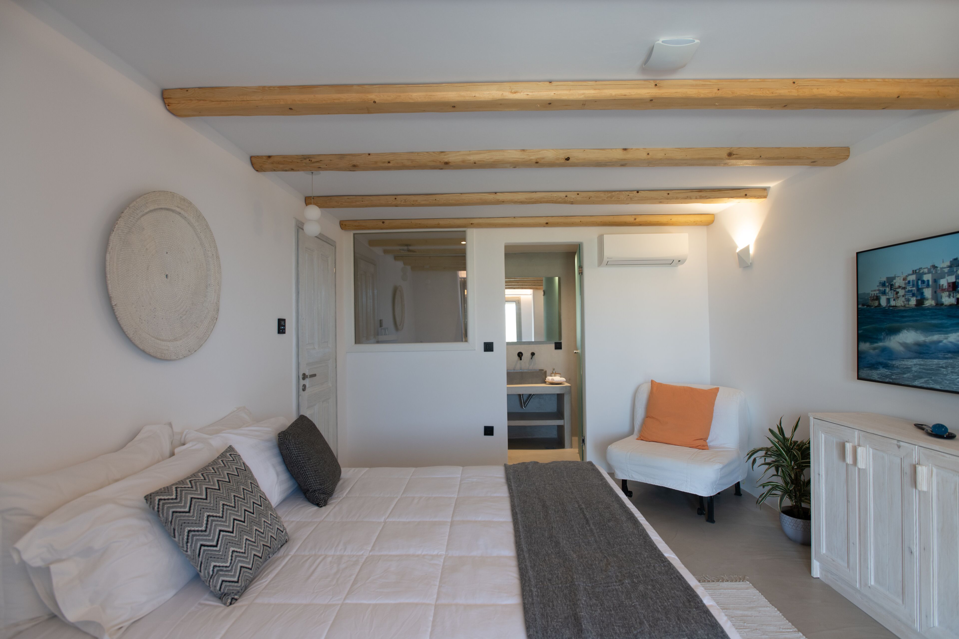 Ein Schlafzimmer mit einem Bett, einem weißen Sofa, einem Sessel und einem Schrank.
