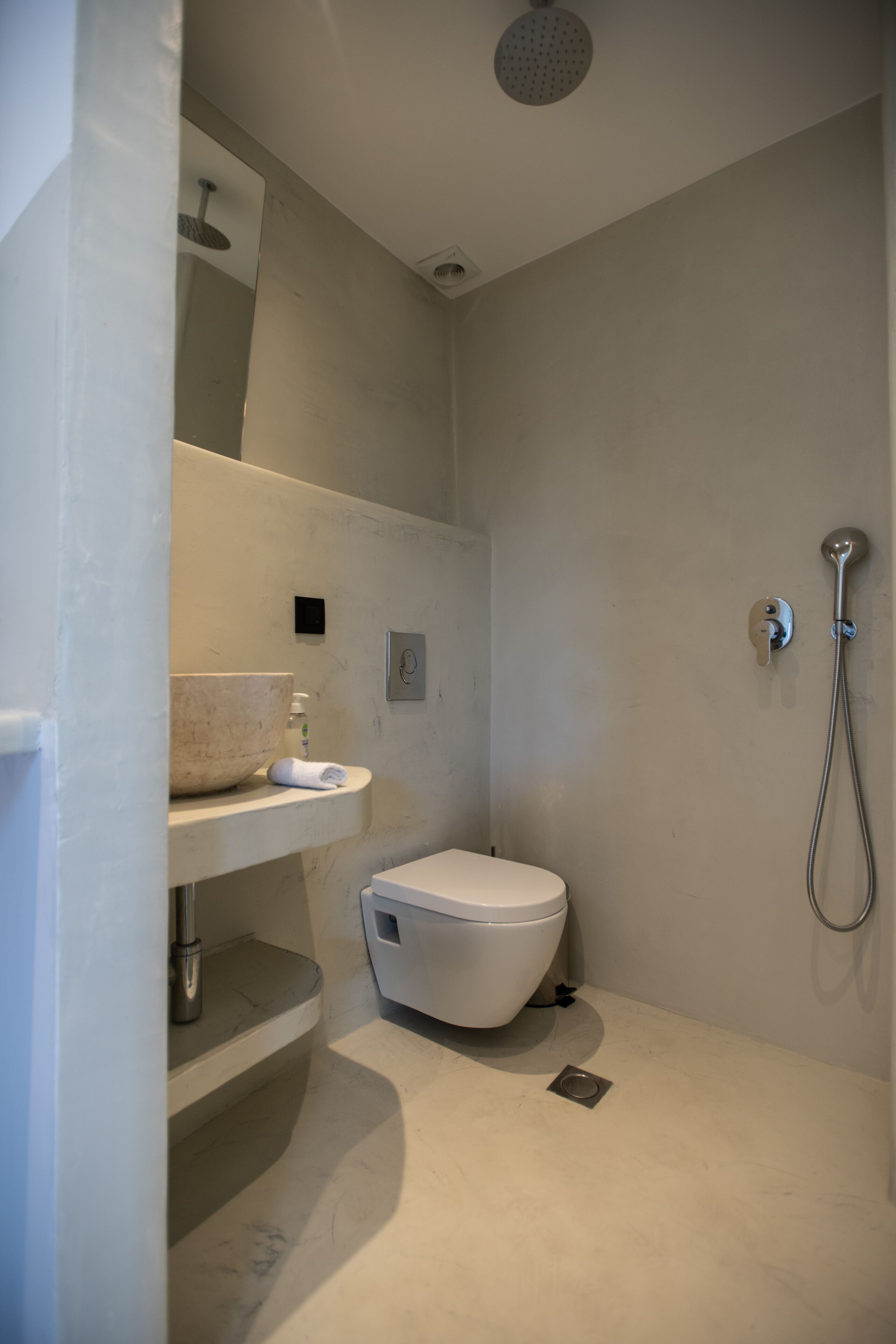 Une salle de bain moderne équipée de toilettes, d’un lavabo et d’une douche.