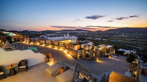 A rooftop terrace with outdoor seating, a view of the landscape, and a sunset. - Mykonos Village (Mykonos)
