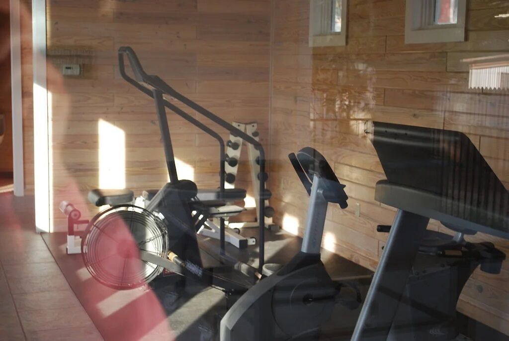 A gym with exercise equipment including a treadmill, stationary bike, and weight machines.
