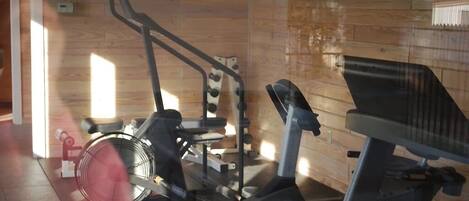 A gym with exercise equipment including a treadmill, stationary bike, and weight machines.