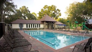 A swimming pool with lounge chairs and a pavilion.