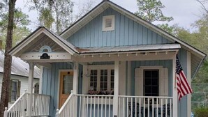 A small, single-story building with a porch and a flag.